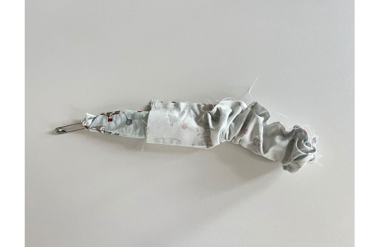 Bring through the safety pin to there other end of the tube gently